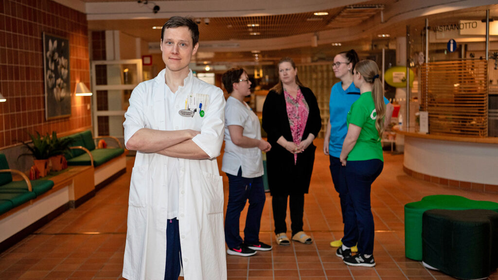 OKKS:n lääkäri kuvassa edustalla ja taustalla muuta henkilökuntaa